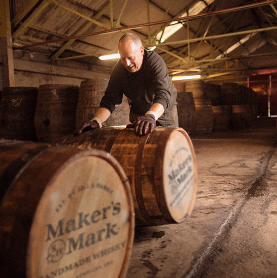 A man rolling a Maker’s Mark barrel at the distillery