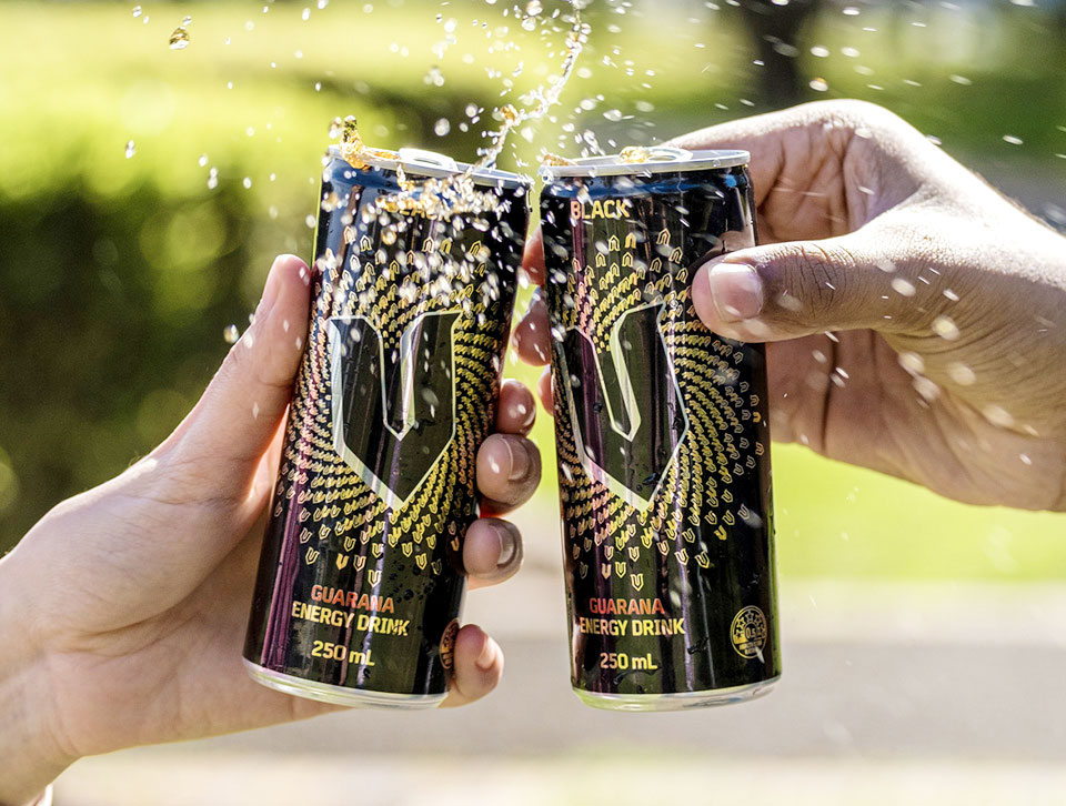 Two hands holding the V Black cans and clinking them together in a cheers.