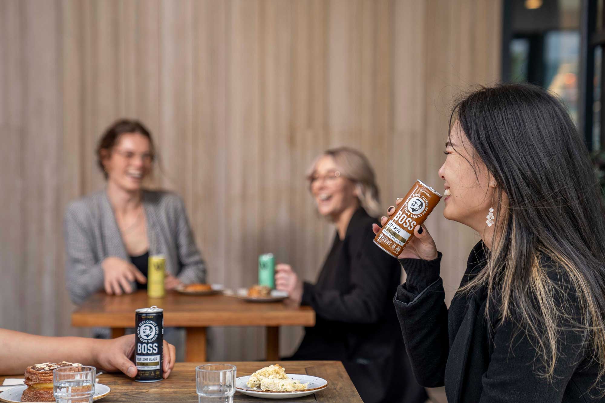 People drinking a can of Boss coffee and V Energy