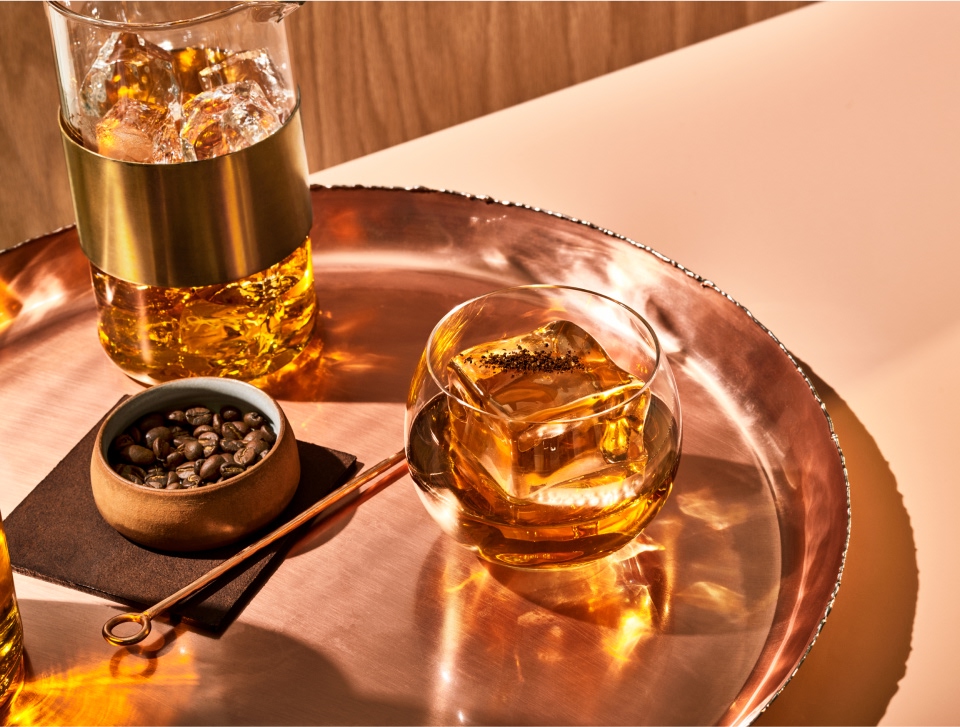 Glasses of Basil Hayden and coffee beans on a bronze tray