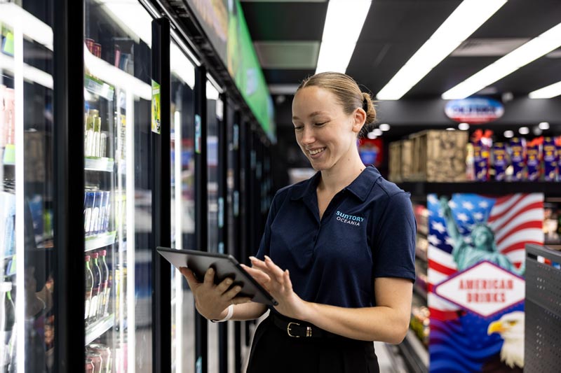 Suntory Oceania worker looking at the work tablet at a retail store