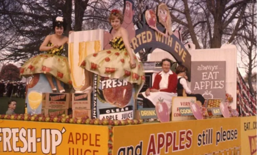 "Fresh Up Apples" signage and models promoting apple juice.