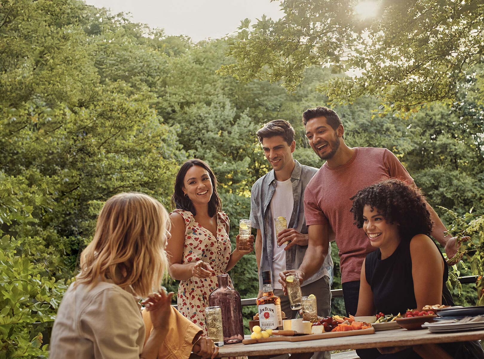 A group of people enjoying party food and a bottle of Jim Beam