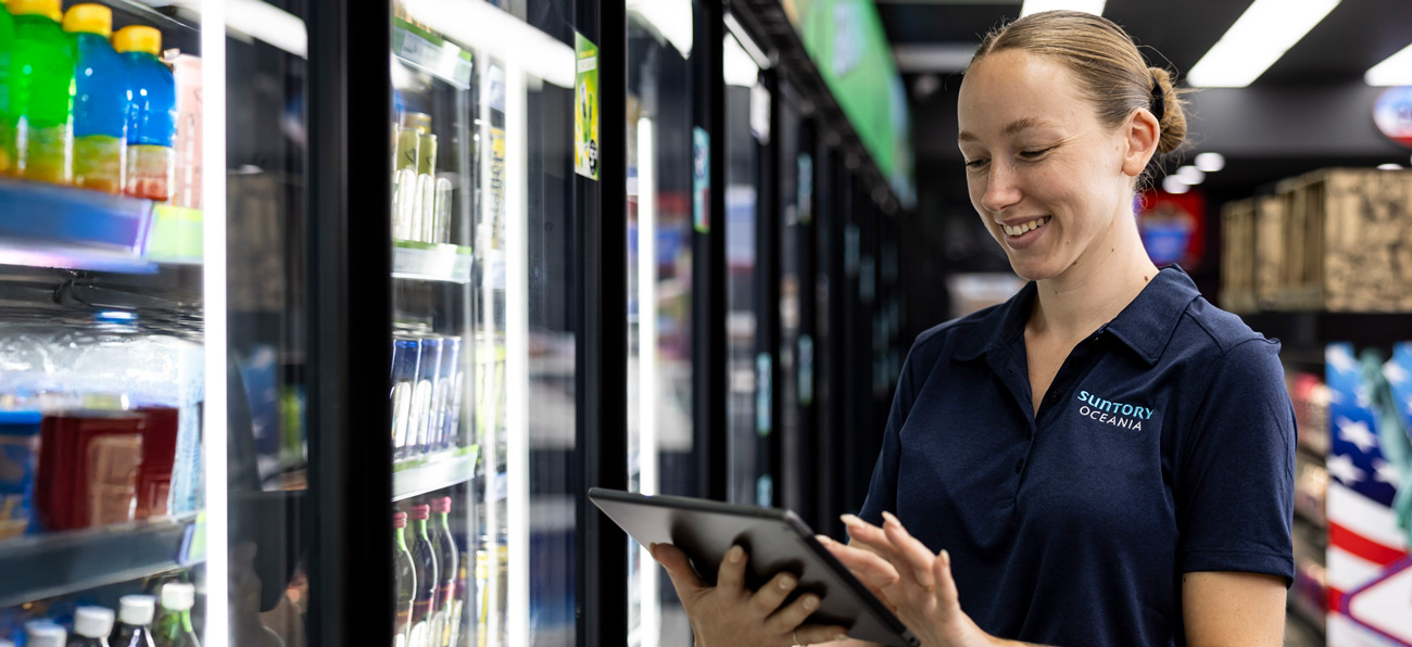 Suntory Oceania worker looking at the work tablet at a retail store