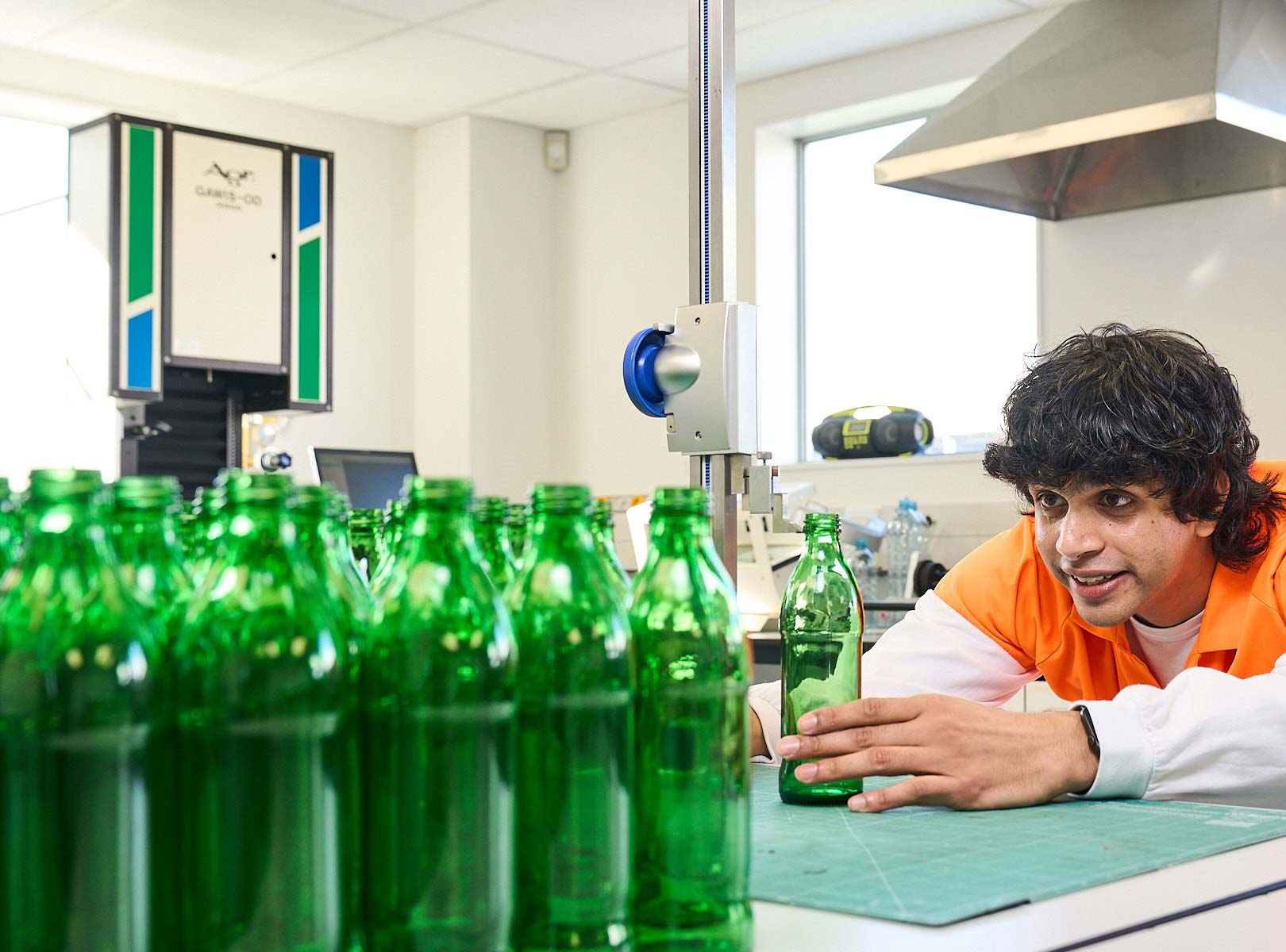 Worker in a lab examining glass bottles