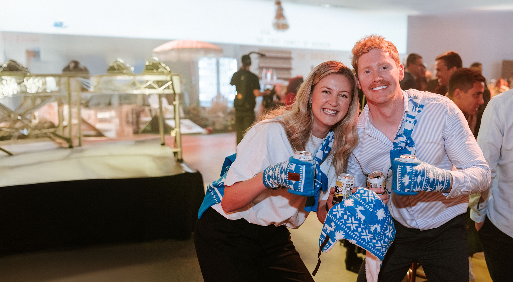 Two people at a event wearing can holder gloves and caans of minus 196