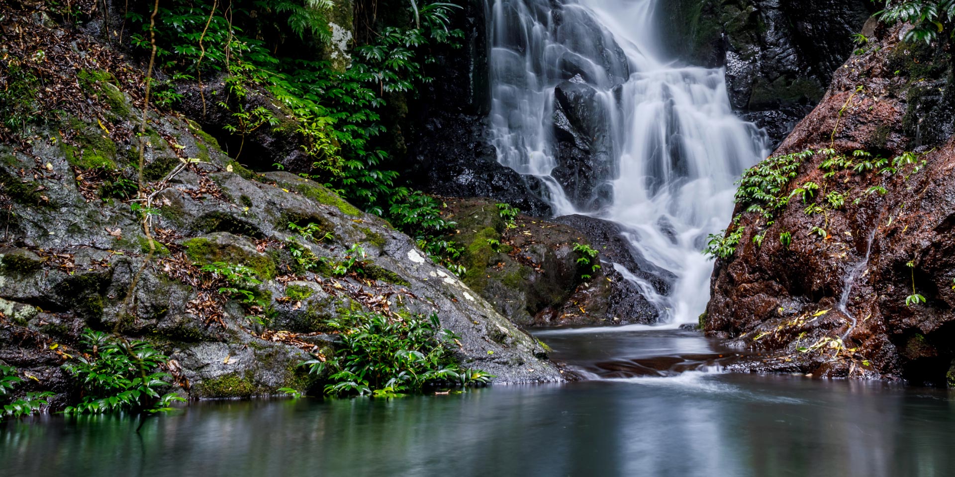 A waterfall in the wilderness flowing into a lake